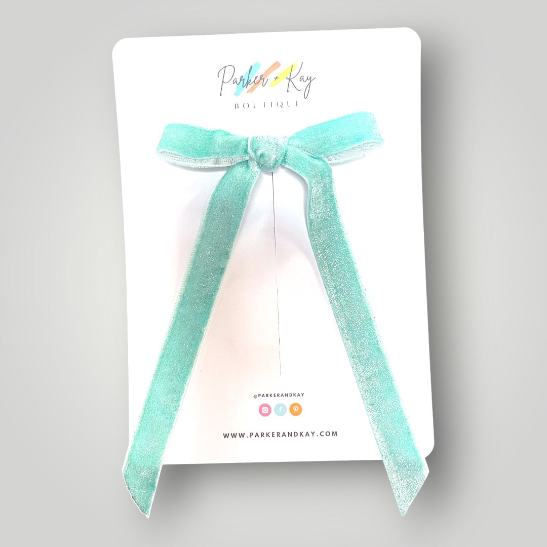 Aqua velvet long tail hair bow on a Parker & Kay branded card