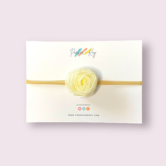 An ivory chiffon rose on a nylon headband presented on a Parker & Kay branded card